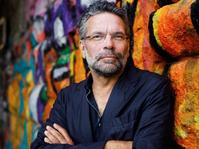 Robert Pfaller steht mit verschränkten Amen und einer dunkelblauen Jacke vor eine Wand mit Graffiti. Er trägt eine Brille und einen Bart © Peter RigaudRobert Pfaller © Peter Rigaud