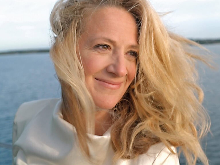Magdalena Bössen ist abgebildet vor einem großen Gewässer. Sie trägt eine weißes Oberteil und ihre blonden Haare wehen im Wind © privatMagdalena Bössen © privat
