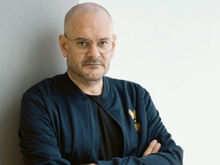 Porträt von Jonas Lüscher, er hat eine Glatze und trägt Brille, Bart sowie eine Trainingsjacke © Peter-Andreas HassiepenJonas Lüscher © Peter-Andreas Hassiepen