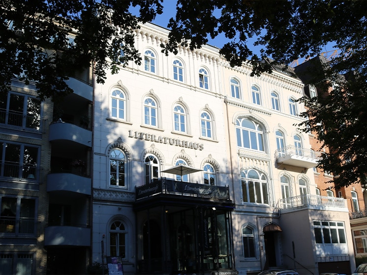 Das Literaturhaus von Außen, fotografiert von den gegenüberliegenden Straßenseite. Bäume ragen an der Seite ins Bild.© Literaturhaus