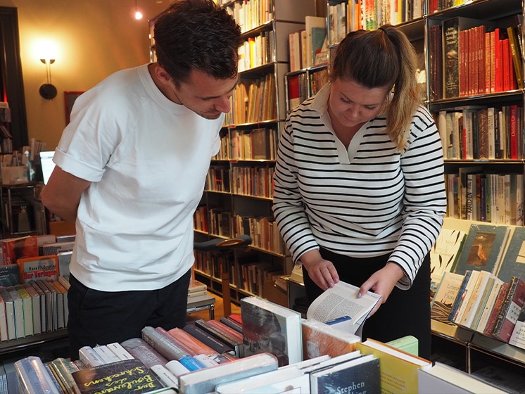 Ein Mann und eine Frau stehen über Bücher gebeugt in der Buchhandlung Samtleben.© Literaturhaus