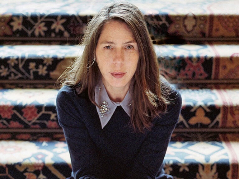 Rachel Kushner sitzt auf einer Treppe. Sie trägt ihre braunen, langen Haare offen über einer hochgeschlossenen Bluse mit großem Kragen © Gabby LaurentRachel Kushner © Gabby Laurent