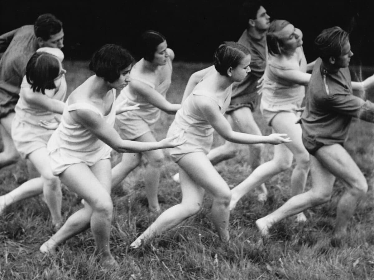 Schwarz-Weiß-Foto: Mehrere Personen in kurzer Kleidung tanzen auf einer Wiese.»Lola Rogge - ein Leben für den Ausdruckstanz«. Florian Noetzel Verlag